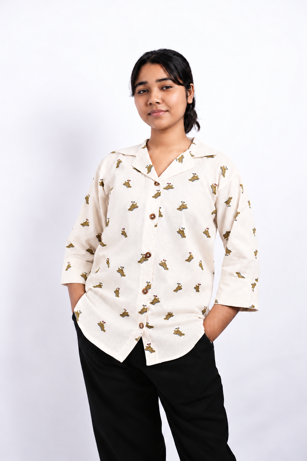 The Decords Dino Daze ladies shirt with an ivory base, dinosaur print, Cuban collar, brown buttons and three-quarter sleeves.